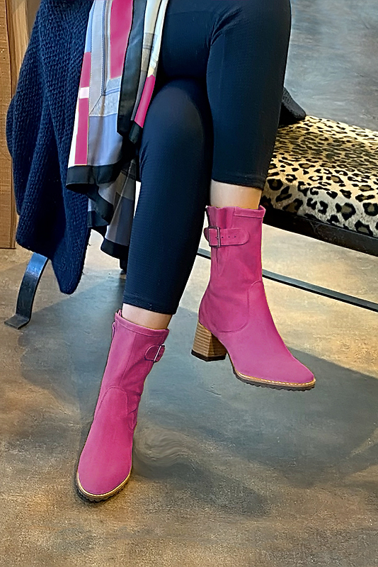 Fuschia pink women's ankle boots with buckles on the sides. Round toe. Medium block heels. Worn view - Florence KOOIJMAN